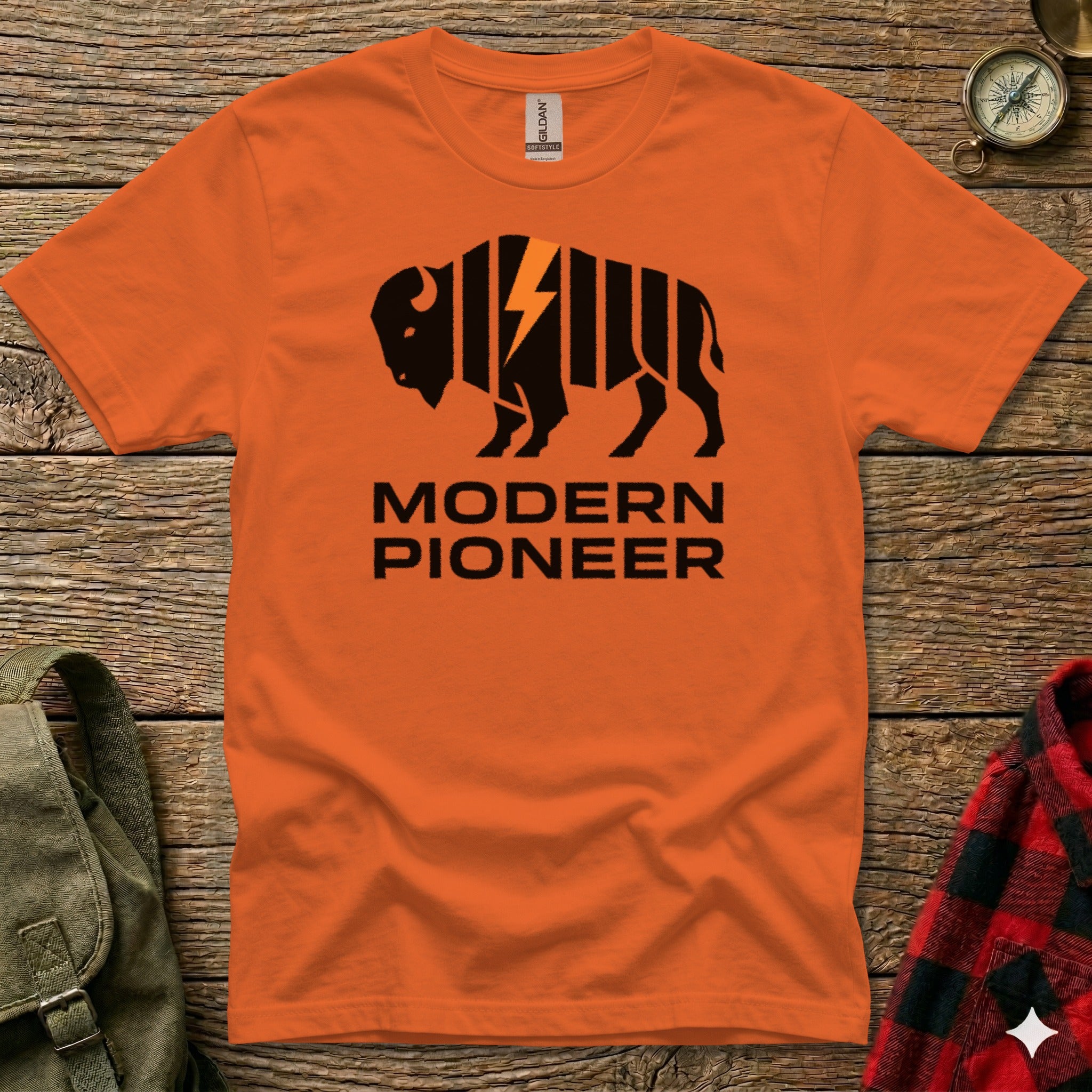 Orange t-shirt with black buffalo and lightning bolt graphic, "MODERN PIONEER" text.