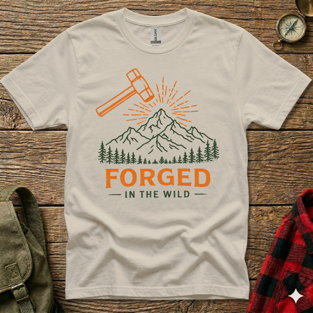 Cream t-shirt with orange hammer, mountains, and "Forged in the Wild" text.