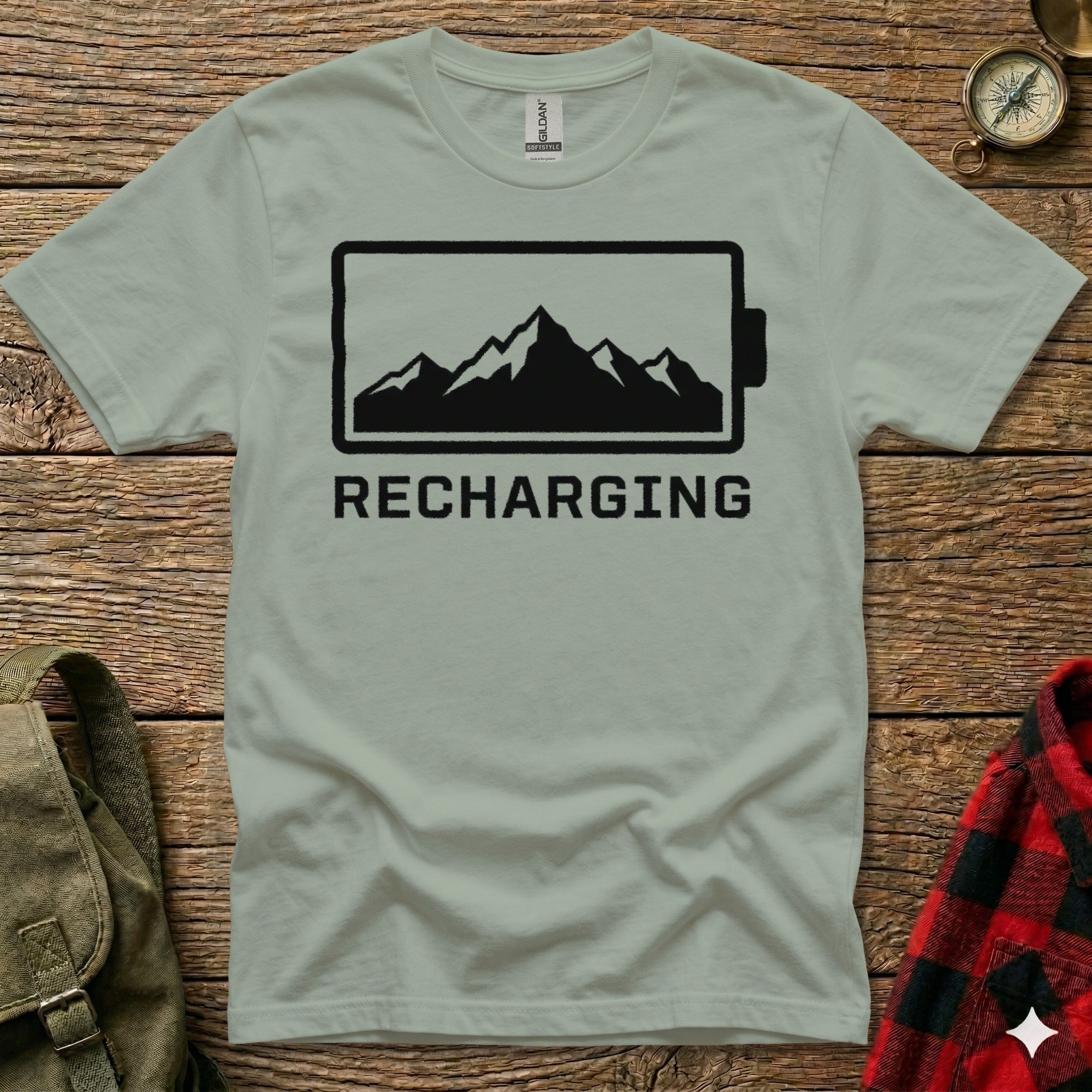 T-shirt with black battery icon and mountain silhouette, "RECHARGING" text.