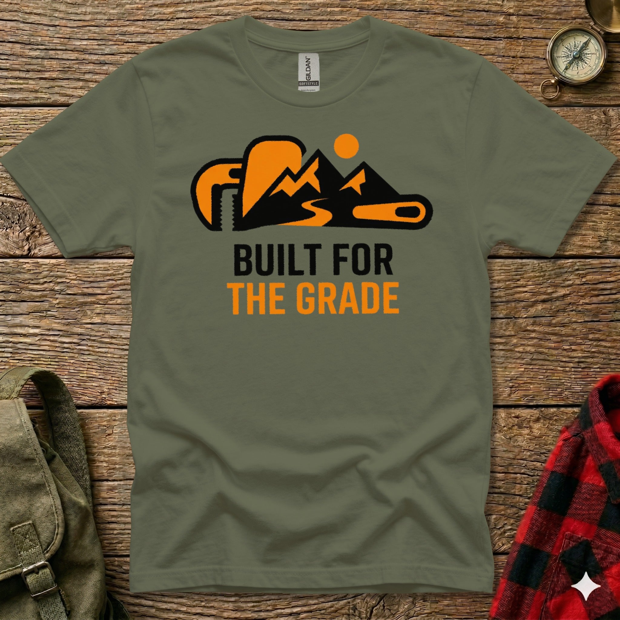Olive green t-shirt with "BUILT FOR THE GRADE" text and mountain graphic.