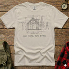 Cream t-shirt with a technical drawing of a cabin and text "BUILT TO SPEC, TESTED BY TRAIL".