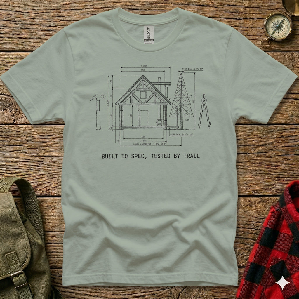 T-shirt with blueprint diagram of a lodge and text "BUILT TO SPEC, TESTED BY TRAIL".