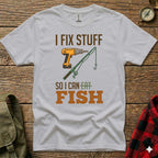 White t-shirt with drill, fishing rod, and text "I FIX STUFF SO I CAN EAT FISH".