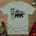 Bear walking through forest with mountains, text B.C.D. Living on that blue dollar.