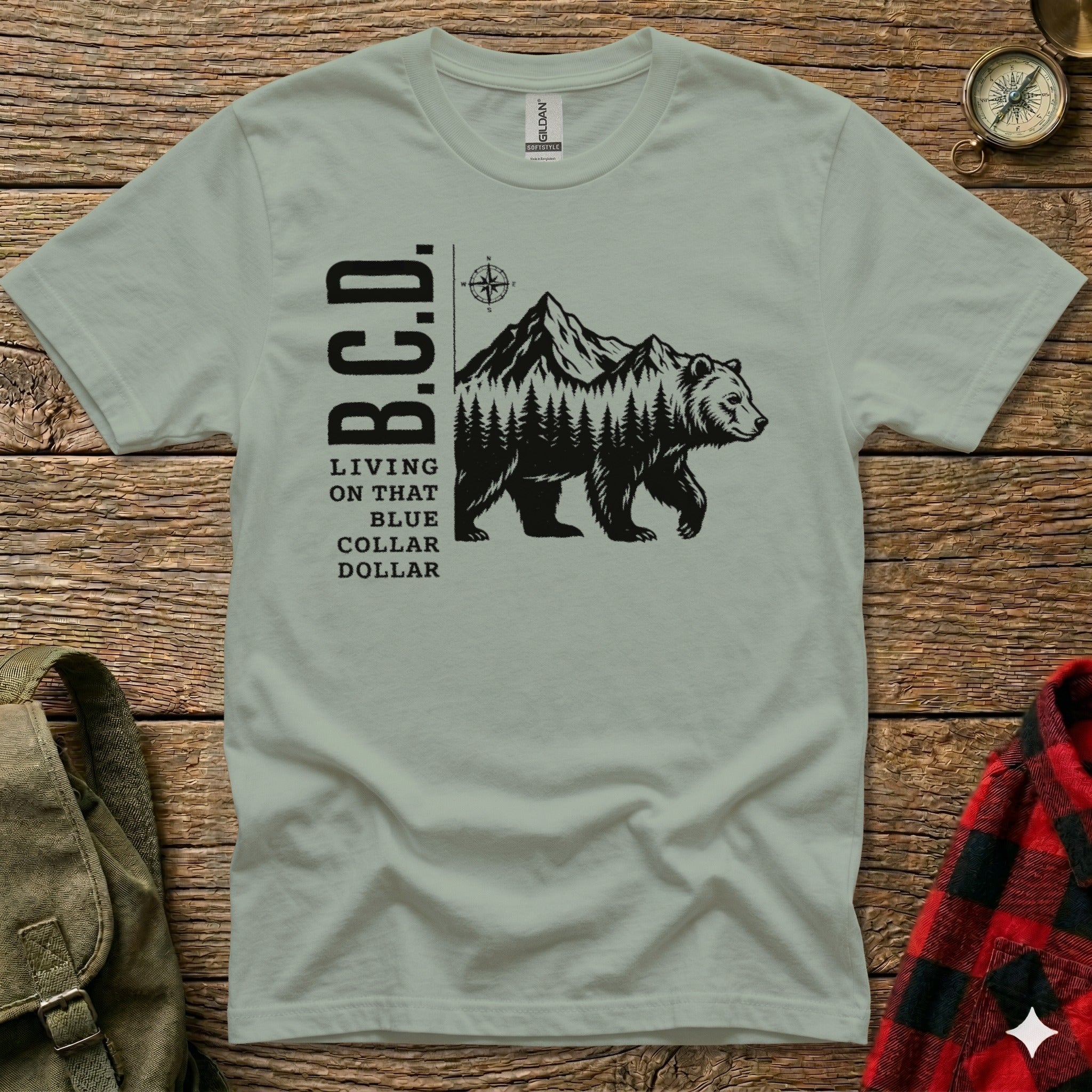 Bear walking through forest with mountains, text B.C.D. Living on that blue dollar.