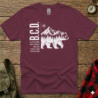 Maroon t-shirt with white "B.C.D." text and mountain bear graphic.