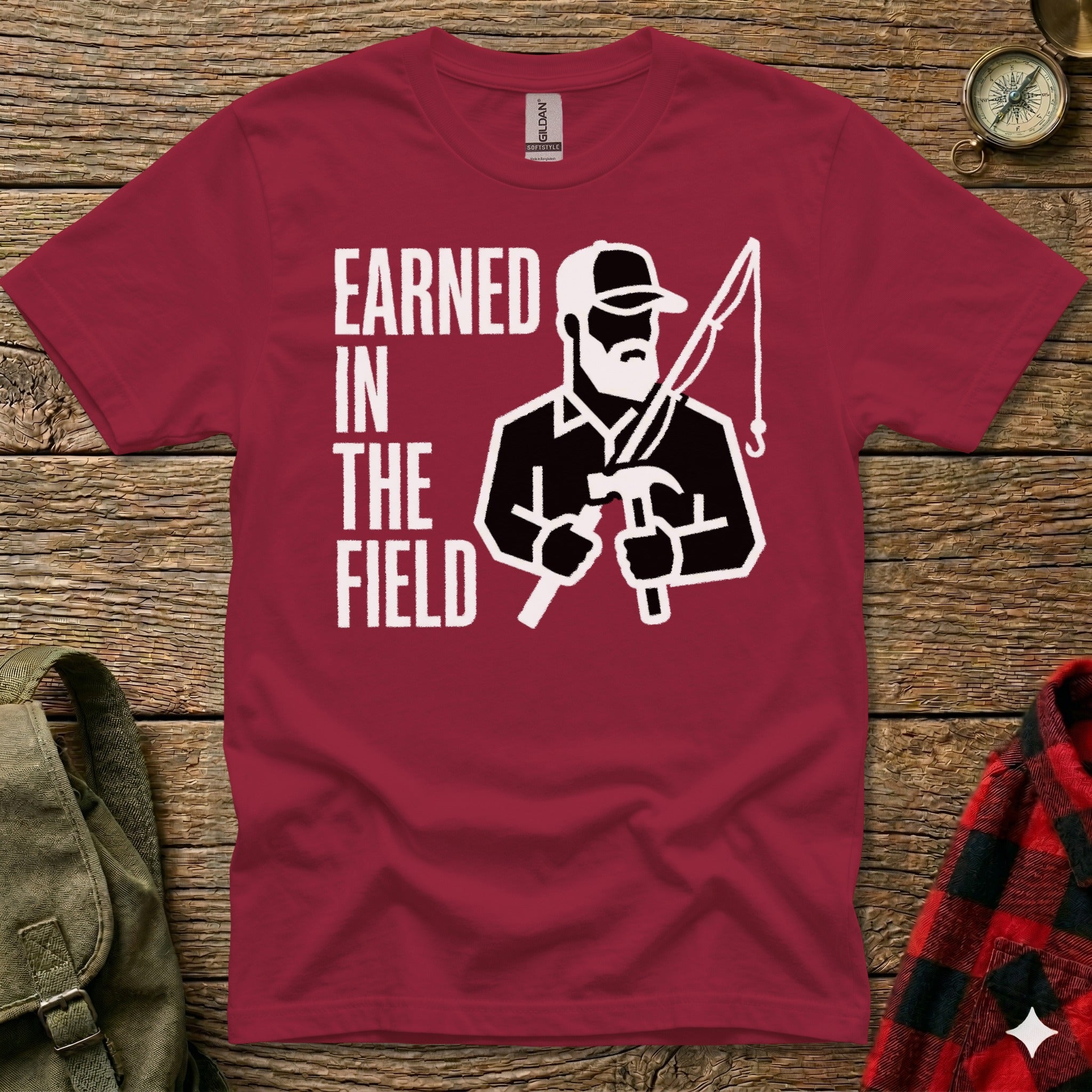 Maroon t-shirt with "Earned in the Field" text and silhouette of a man fishing.