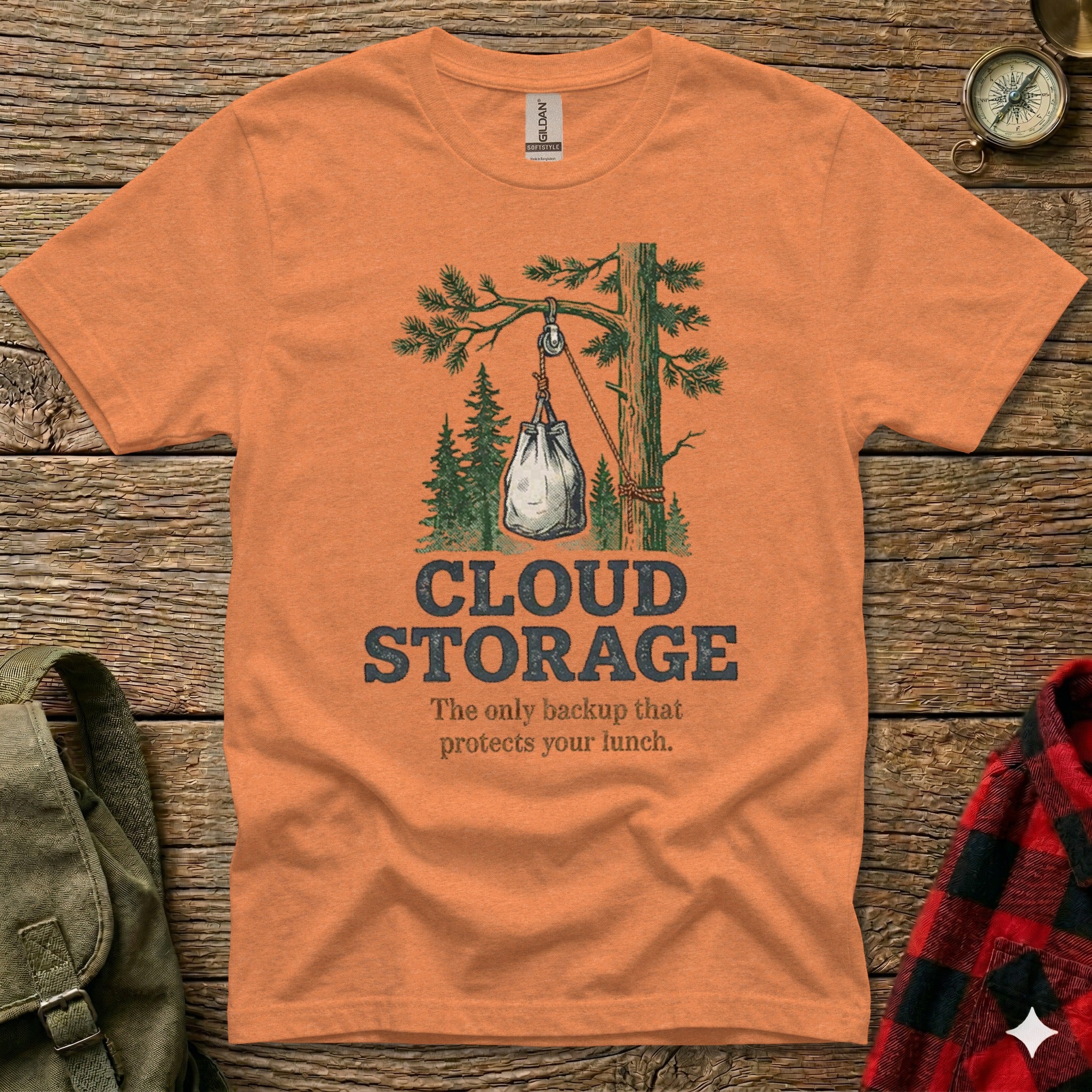 Orange t-shirt with "CLOUD STORAGE" graphic of a bag hanging from a tree.