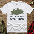 White t-shirt with "Made in the Overtime" text and mountain silhouette.