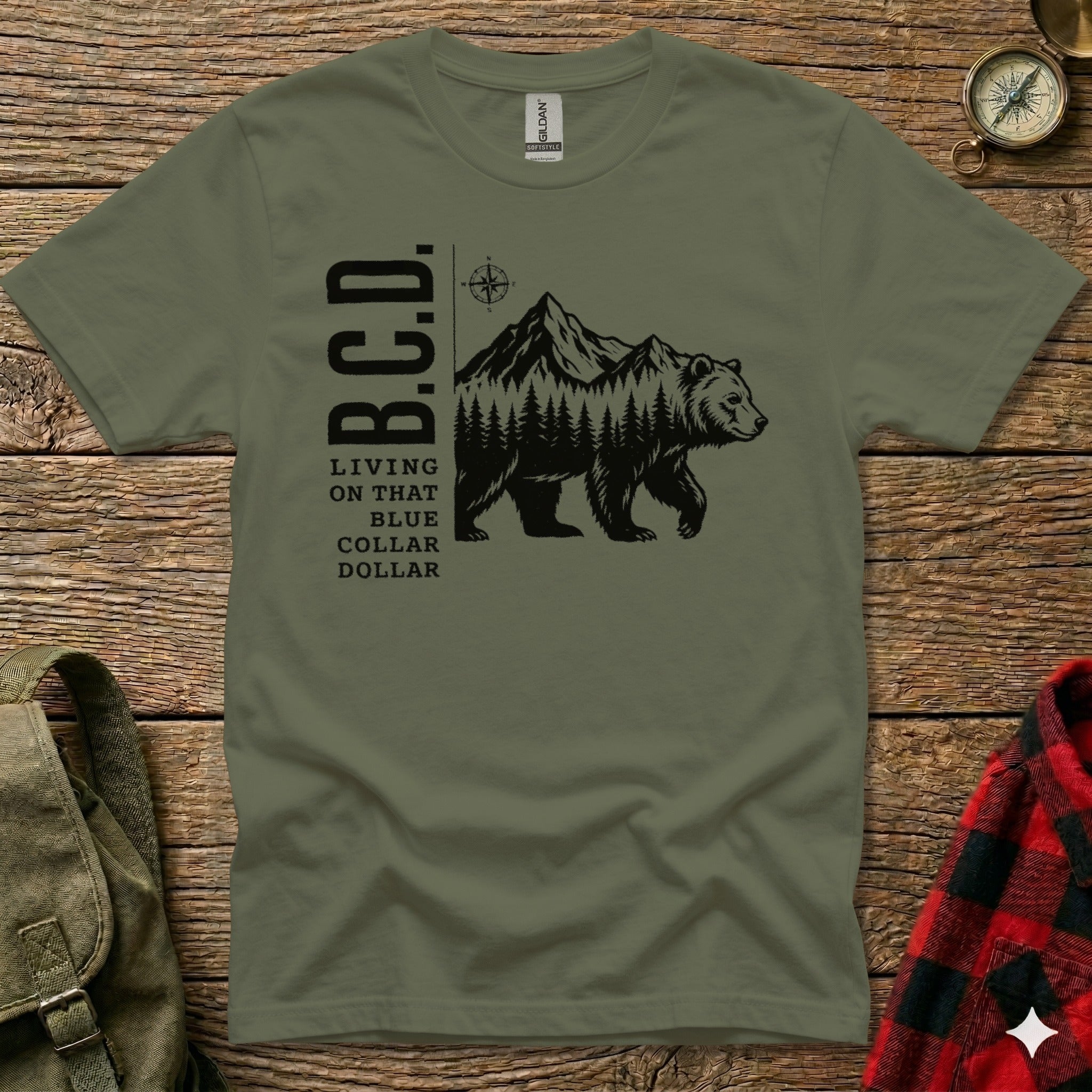 Olive green t-shirt with "B.C.D. LIVING ON THAT BLUE COLLAR DOLLAR" and bear in mountains graphic.