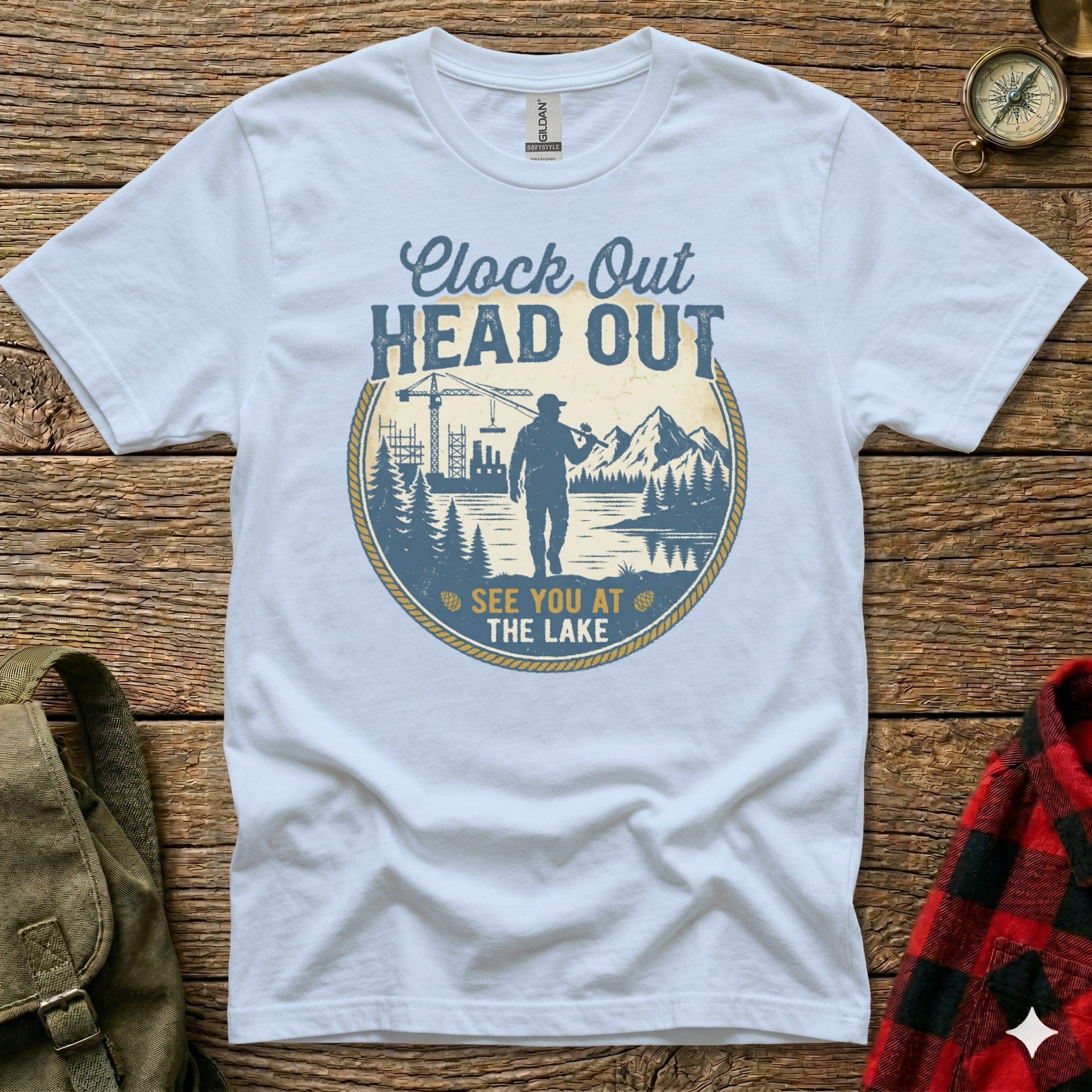White t-shirt with "Clock Out Head Out See You At The Lake" text and nature graphic.