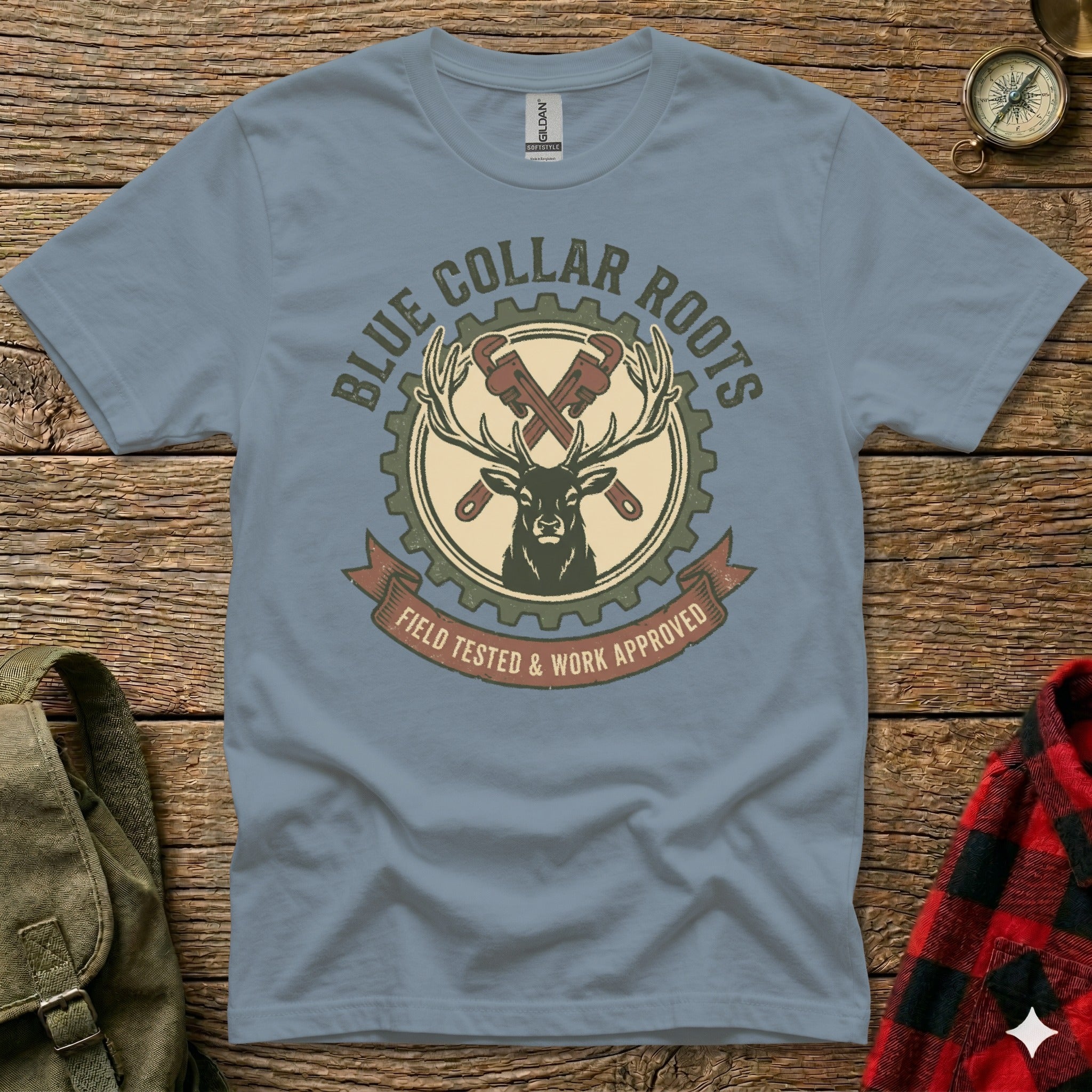 Blue Collar Roots logo with deer, crossed wrenches, and gear on a t-shirt.