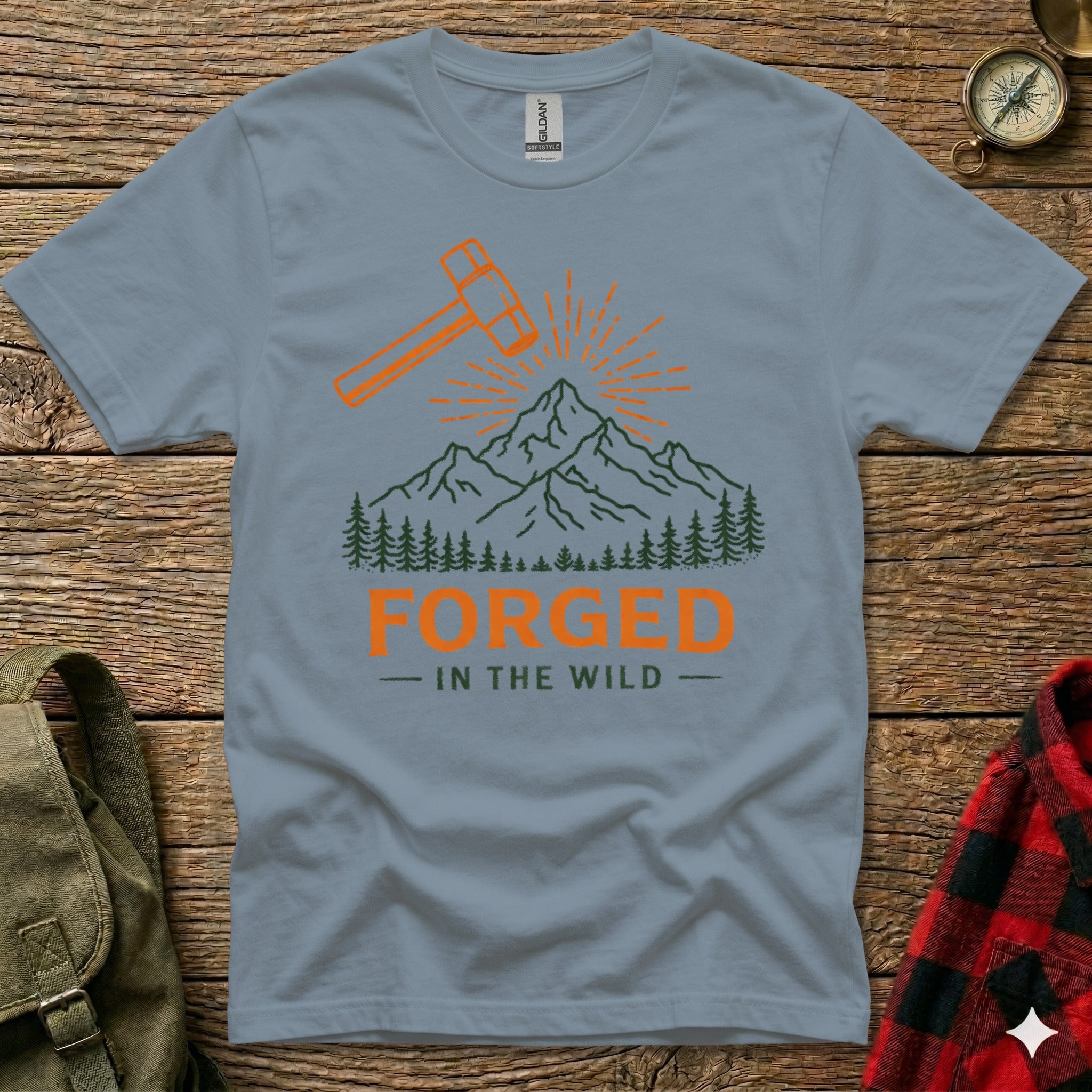 Gray t-shirt with "Forged in the Wild" text and mountain graphic.