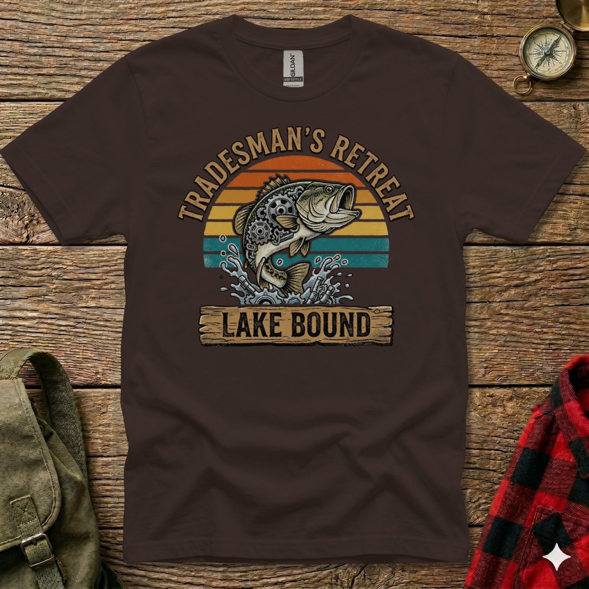 Brown t-shirt with fish jumping out of water and "Tradesman's Retreat Lake Bound" text.
