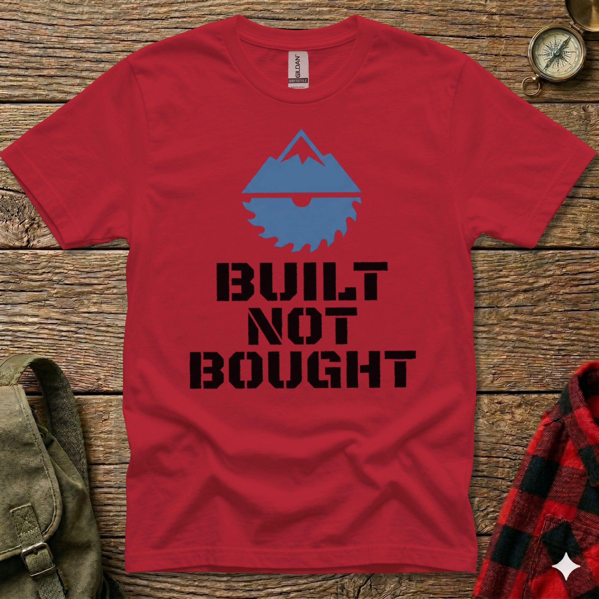 Red t-shirt with mountain and saw graphic and "Built Not Bought" text.