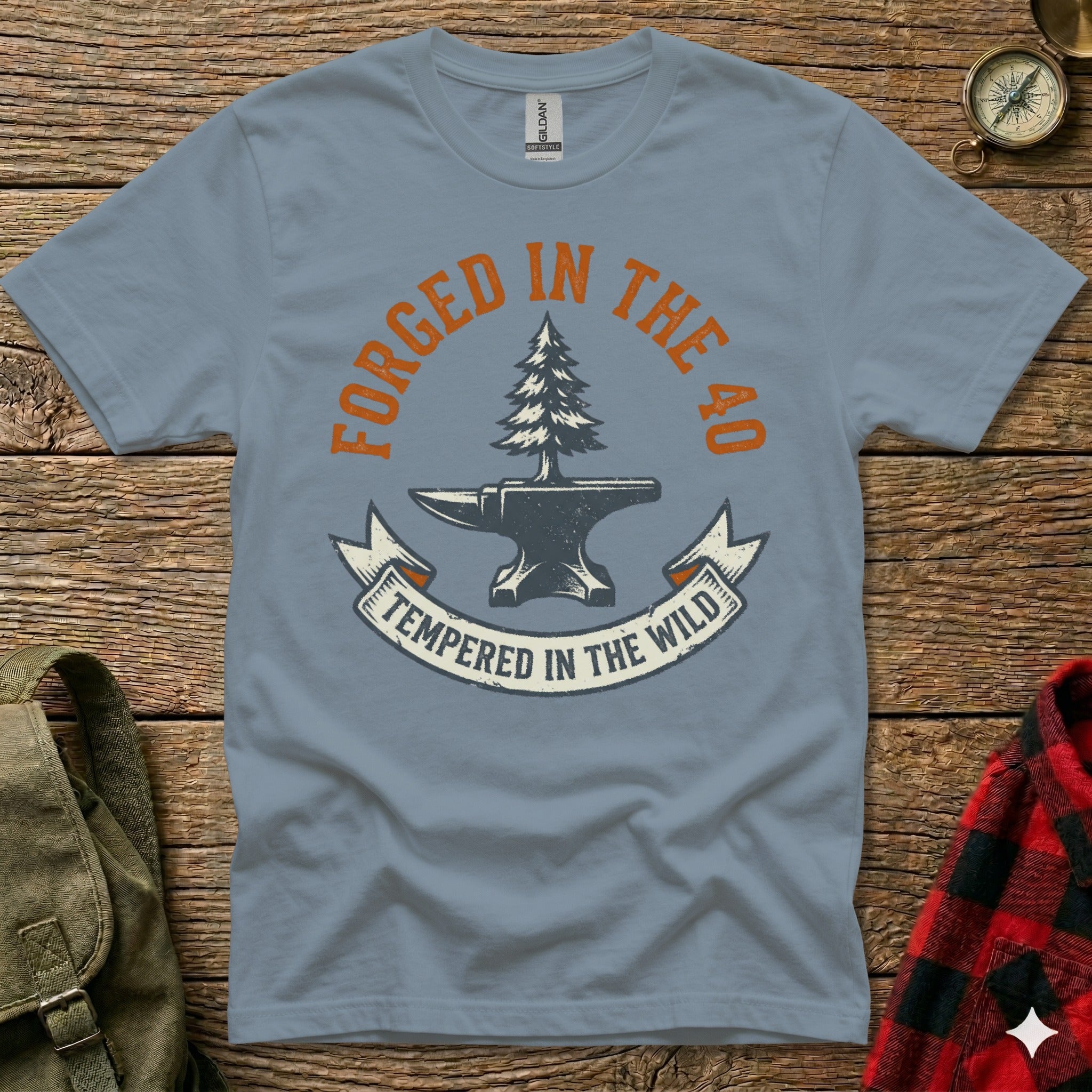Grey t-shirt with "Forged in the 40, Tempered in the Wild" text and anvil/tree graphic.