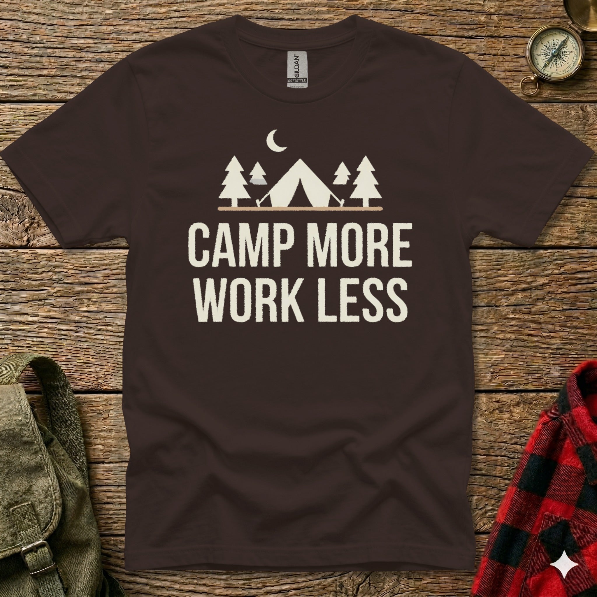 Dark brown t-shirt with white text and camping graphic reading "CAMP MORE WORK LESS".