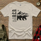 T-shirt with B.C.D. text, mountains, and bear illustration.