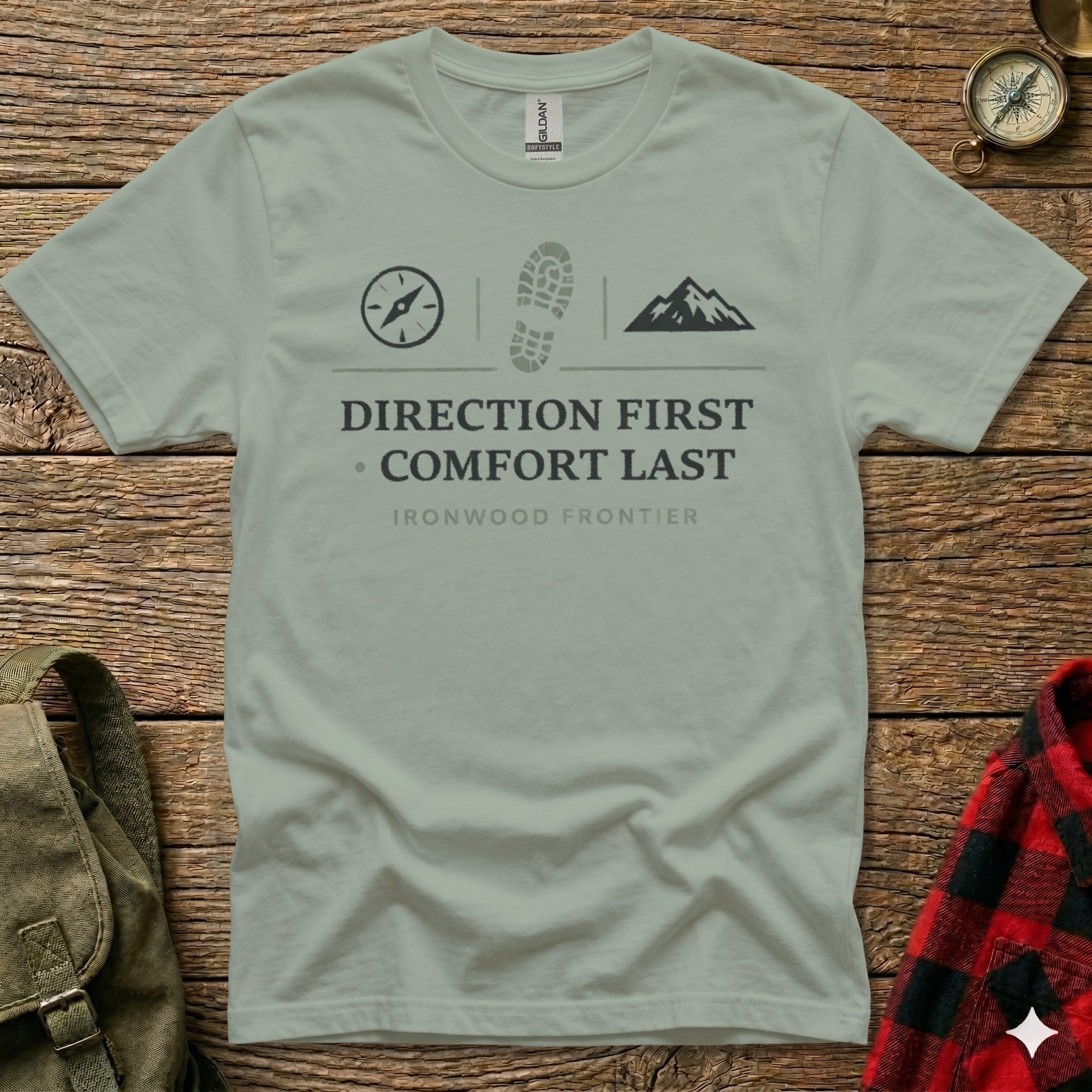 T-shirt with compass, boot print, mountain graphics and "Direction First Comfort Last" text.