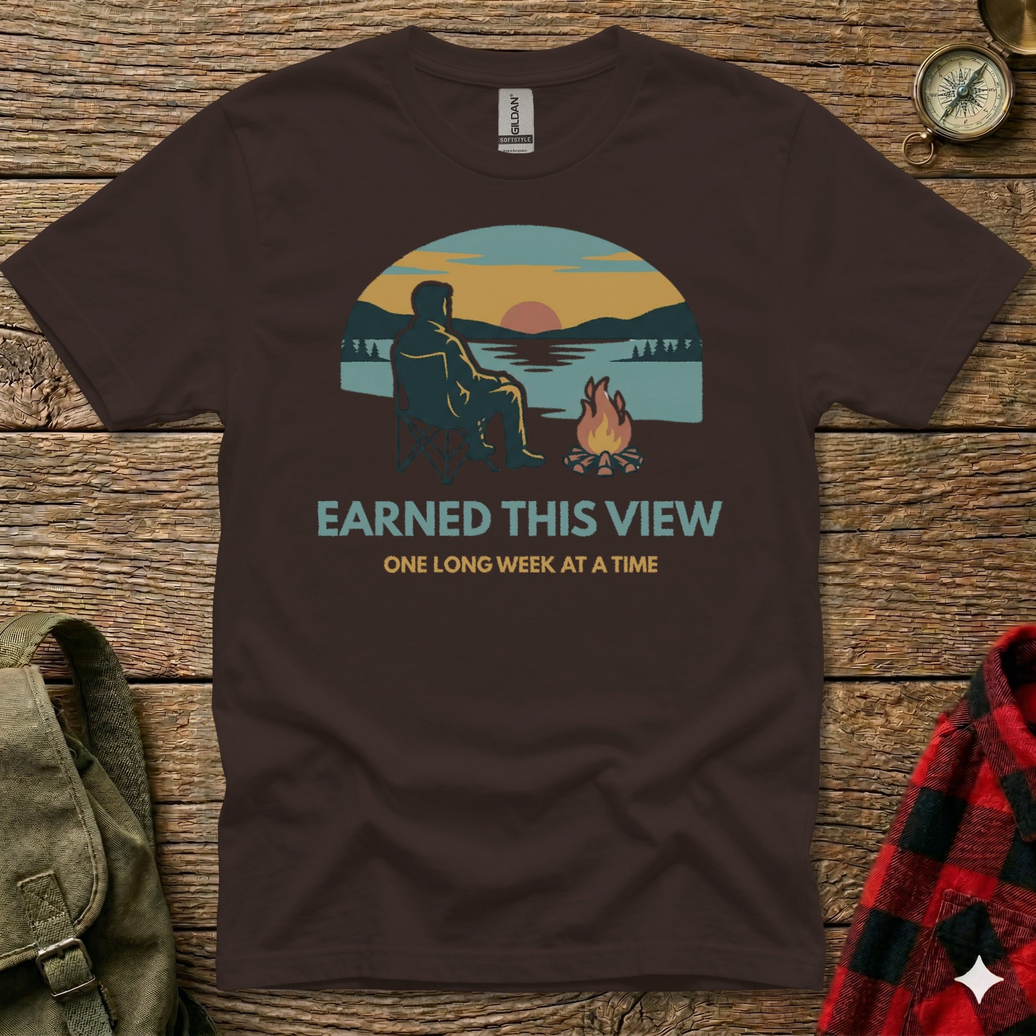Brown t-shirt with "EARNED THIS VIEW ONE LONG WEEK AT A TIME" text and graphic.