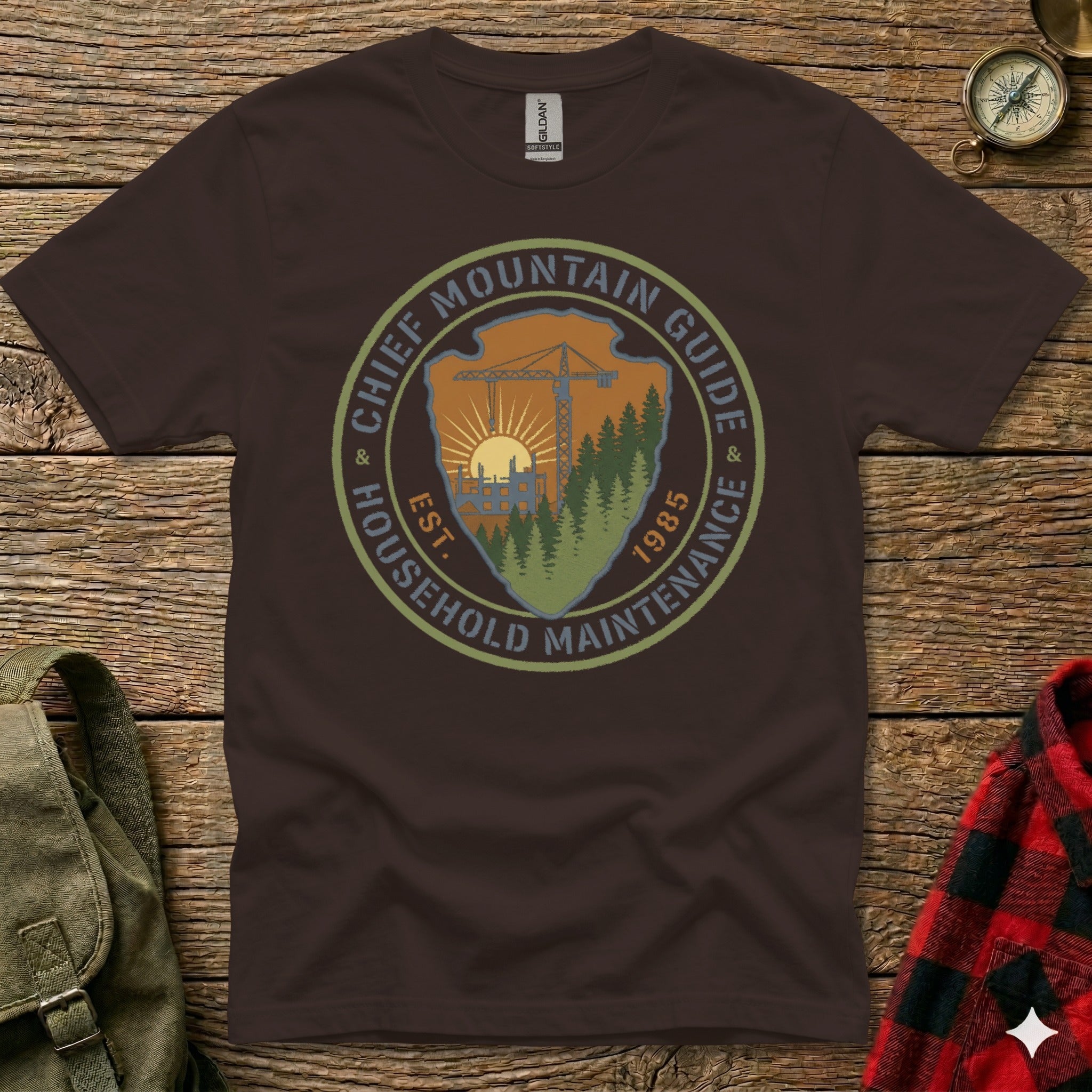 Brown t-shirt with "Chief Mountain Guide Household Maintenance" circular logo.