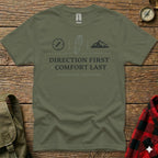 Olive green t-shirt with compass, boot, and mountain graphics and text.