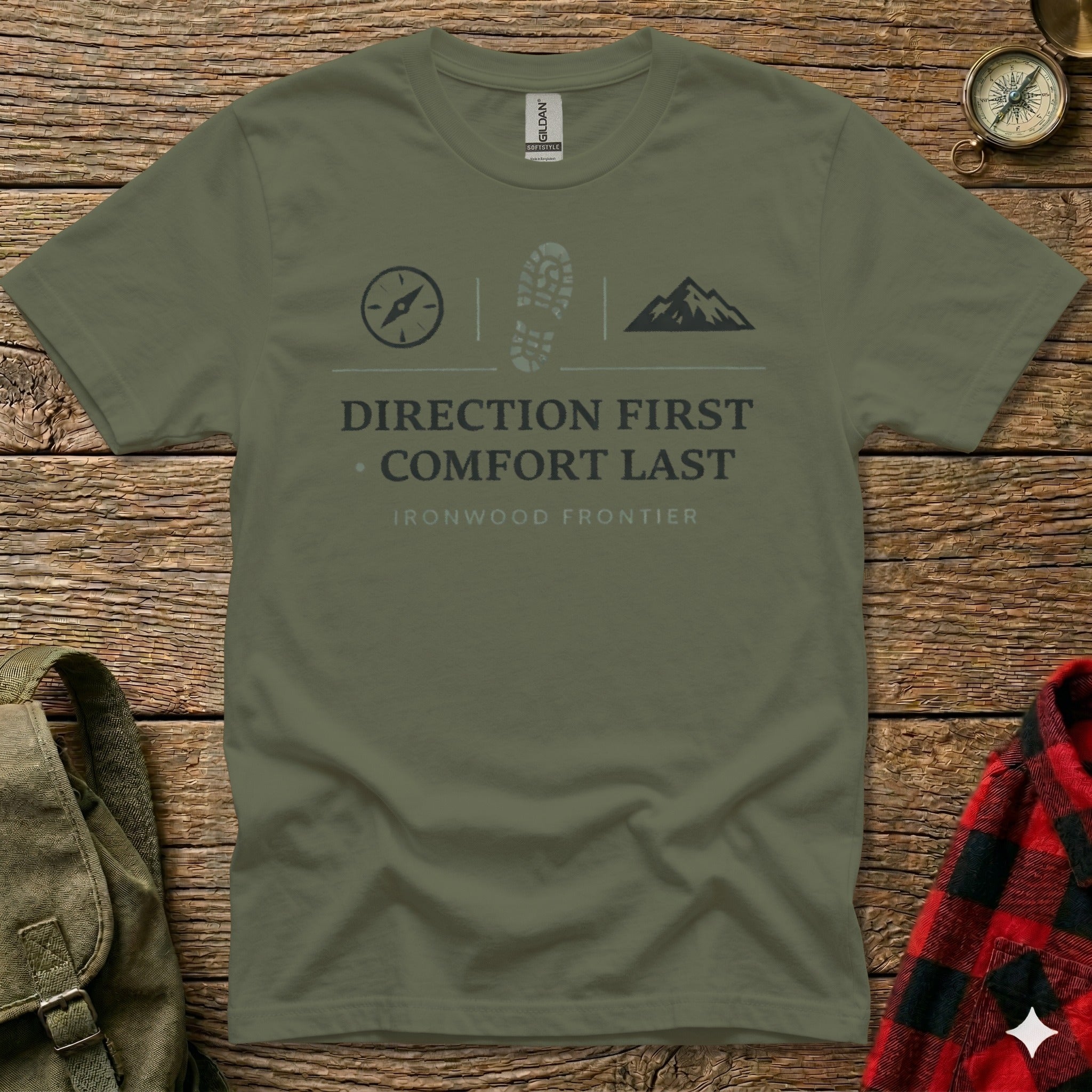 Olive green t-shirt with compass, boot, and mountain graphics and text.
