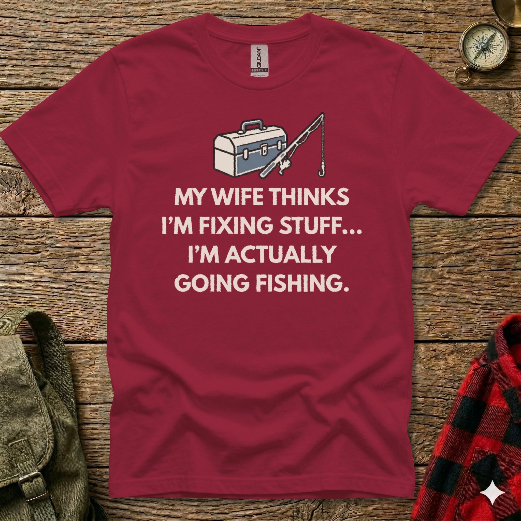 Burgundy t-shirt with "My wife thinks I'm fixing stuff... I'm actually going fishing" text.