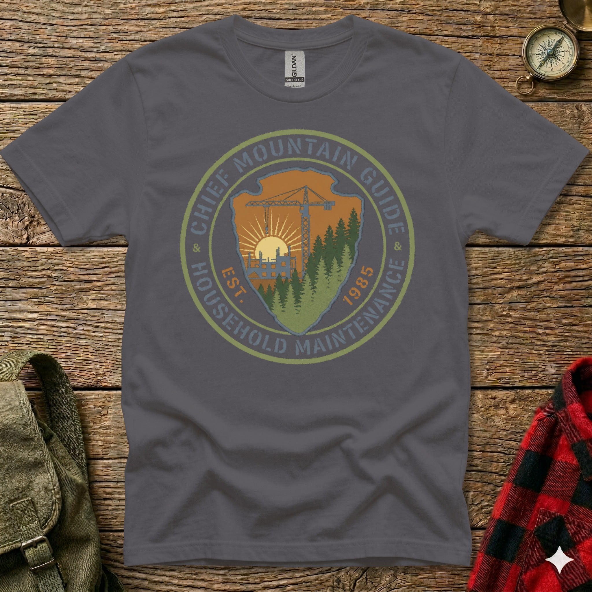 T-shirt graphic with "Chief Mountain Guide Household Maintenance" logo and 1985 establishment date.
