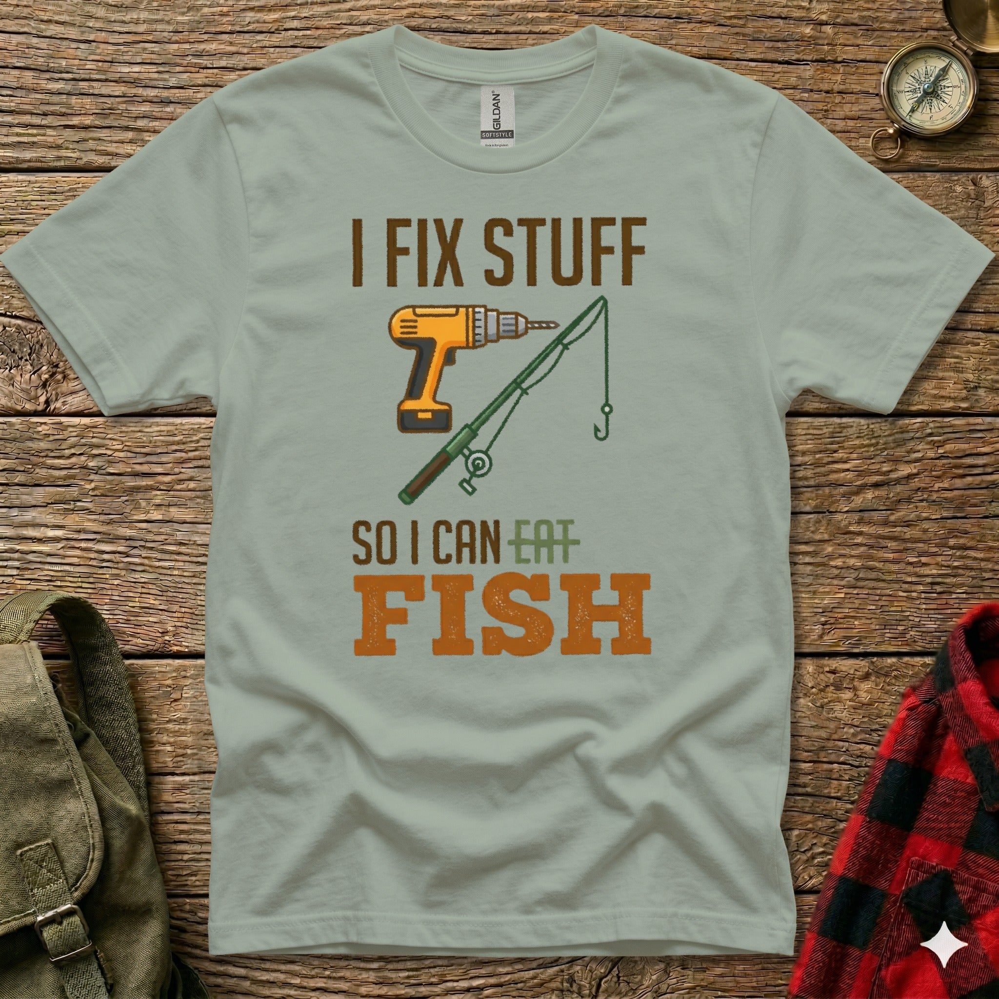 Green t-shirt with "I FIX STUFF SO I CAN EAT FISH" text and drill and fishing rod graphic.