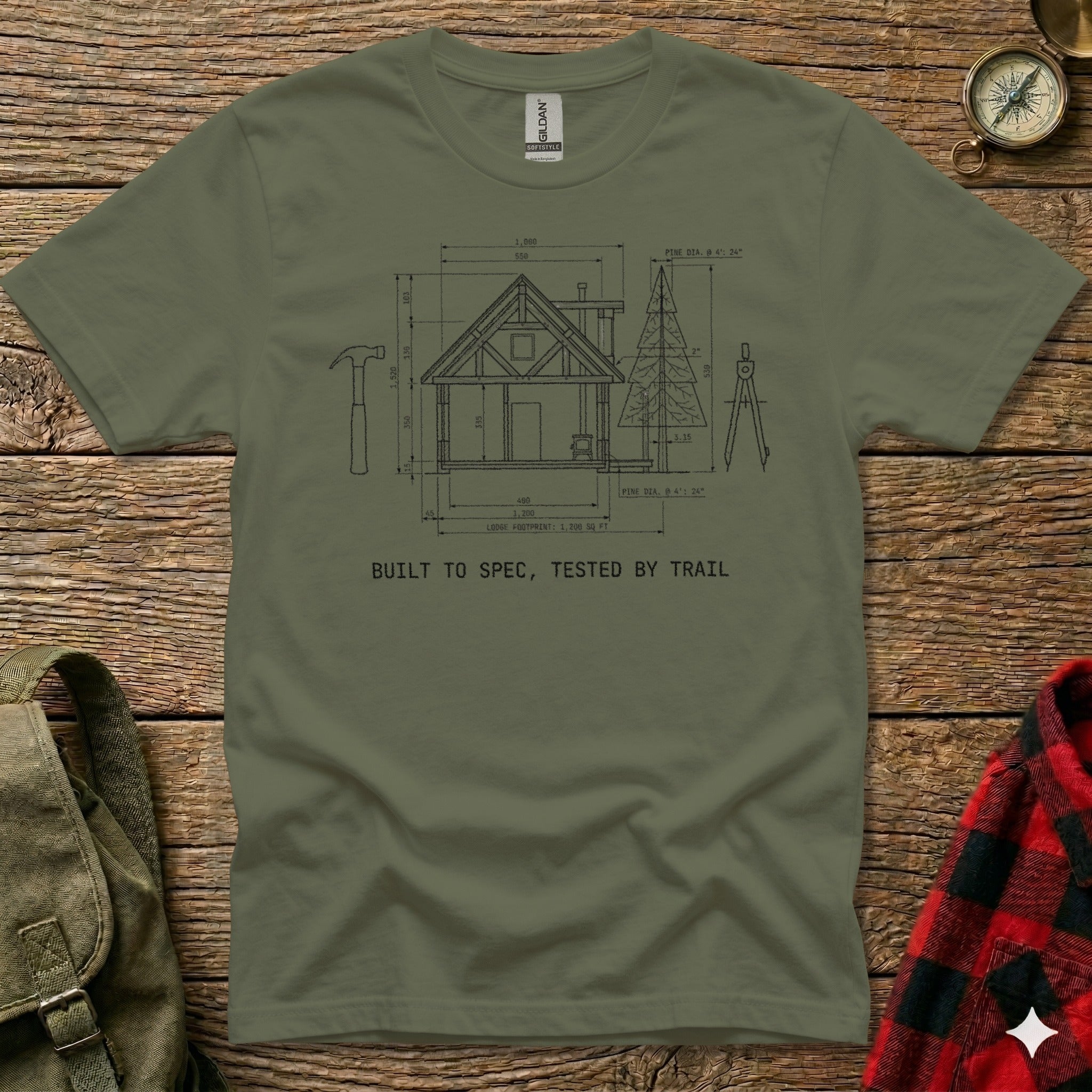 Blueprint of a cabin on a t-shirt with "Built to Spec, Tested by Trail".