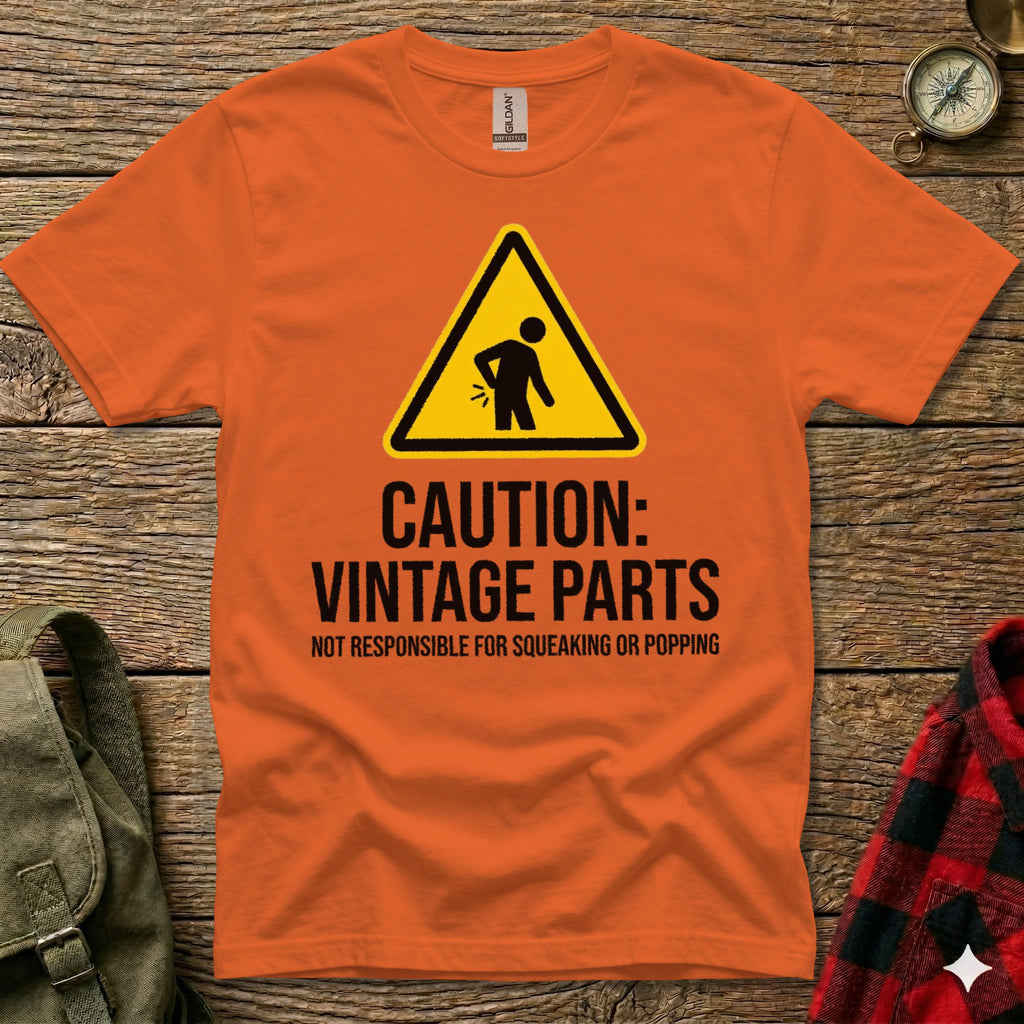 Orange t-shirt with "Caution: Vintage Parts" warning sign and text.