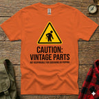 Orange t-shirt with "Caution: Vintage Parts" warning sign and text.