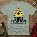 Grey t-shirt with black text and caution sign about vintage parts.
