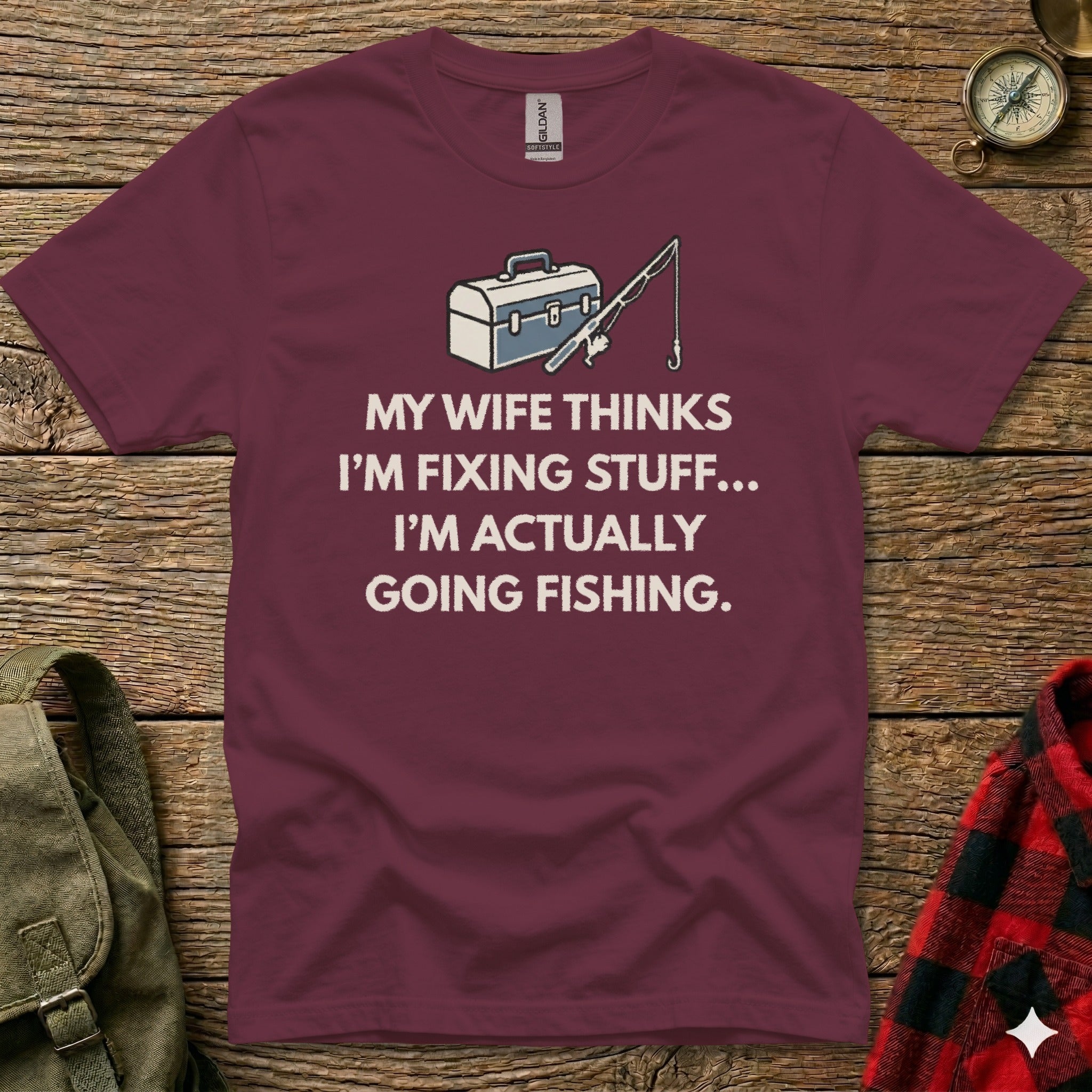 Maroon t-shirt with "My wife thinks I'm fixing stuff... I'm actually going fishing." graphic.